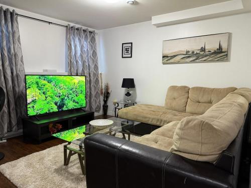 a living room with a couch and a flat screen tv at Home away from home in St. John's