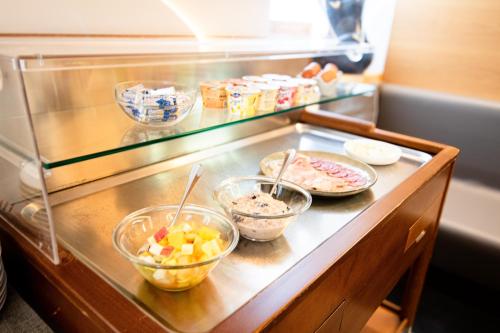ベリンツォーナにあるLocanda Marcoの冷蔵庫の中に食べ物の入ったボウルが置かれたカウンター