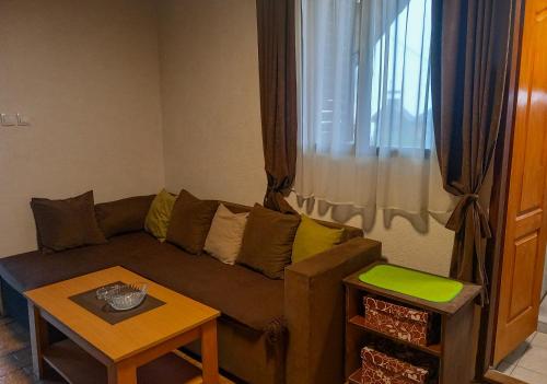 a living room with a couch and a table at Cozy Cabin in Sekulić 