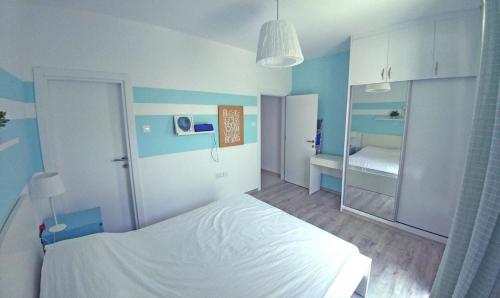 a blue and white bedroom with a bed and a mirror at Трехкомнатные апартаменты в жилом комплексе Caesar Beach F14 Flat4 in Boğaz