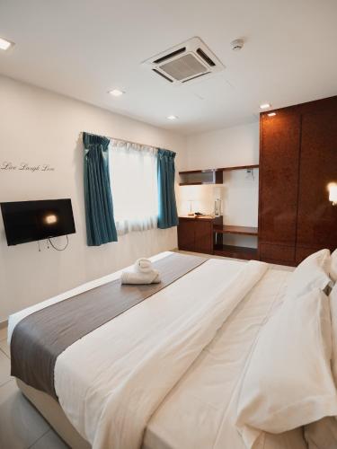 a large white bed in a room with a television at Eco Roomy Hotel in Kuala Lumpur