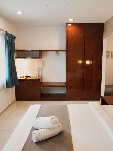 a room with a bed with two towels on it at Eco Roomy Hotel in Kuala Lumpur
