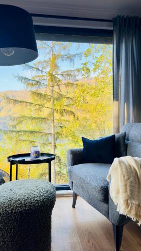 a living room with a couch and a large window at Cabana207 - Private Mountain Cabin with Hot Tub in Bulz