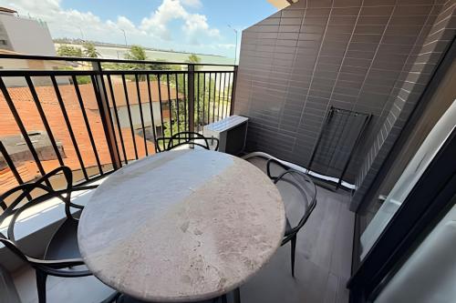 a table and chairs sitting on a balcony at 403 Ocean Art Park - Take Home in Tambaú