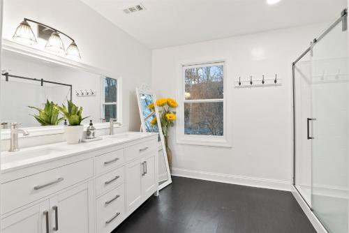 a white bathroom with two sinks and a shower at Blue Mountain Song- Massanutten Home with Hot tub! in Hopkins Spring