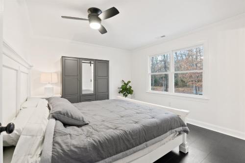 a white bedroom with a bed and a ceiling fan at Blue Mountain Song- Massanutten Home with Hot tub! in Hopkins Spring