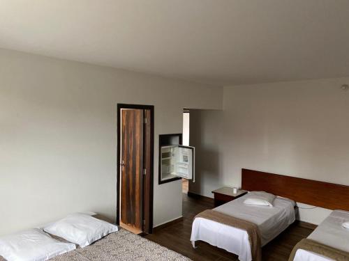 a hotel room with two beds and a television at Hotel Vitoria Palace varginha in Varginha