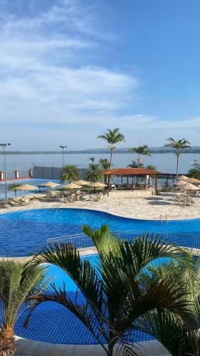 巴西利亚Estiloso Flat Particular no Lake Side的棕榈树海滩旁的大型游泳池