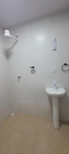 a white bathroom with a sink and a toilet at Hall dos parques in Belém
