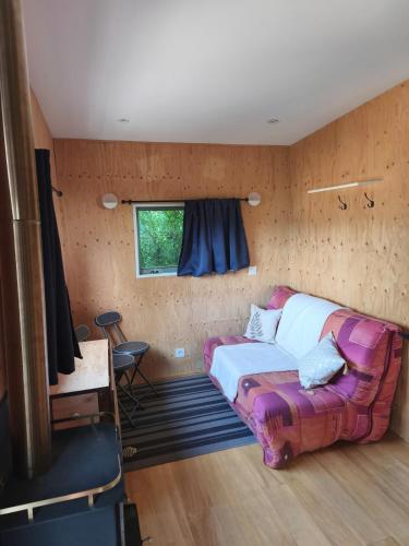 a bedroom with a bed and a window at Tiny house chaleureuse en Matheysine in Saint-Jean-de-Vaux