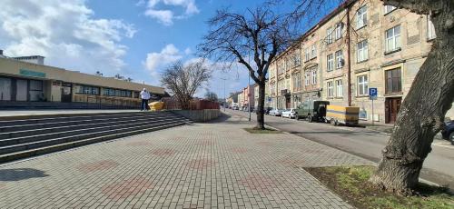 a person walking down a street next to a building at Serce Przemyśla Classic in Przemyśl