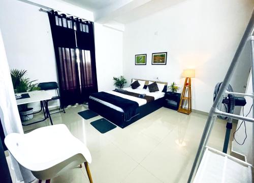 a living room with a bed and a chair in it at Saya's Abode - Railview Suites in Tezpur