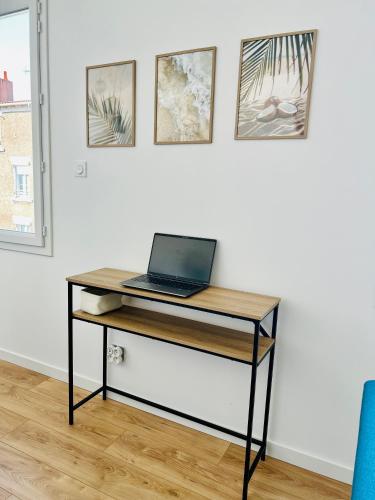 a desk with a laptop on it in a room at Appartement proche Ancenis - Loire et Vélo in Liré
