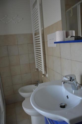 a bathroom with a white sink and a toilet at La Casa di Abramo in Venosa