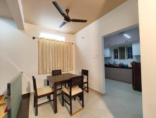 ein Esszimmer mit Tisch und Stühlen und eine Küche in der Unterkunft Namasvi 2Bedroom AC House in Narasimharaja Puram