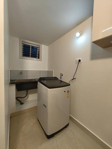a kitchen with a small refrigerator in a room at Namasvi 2Bedroom AC House in Narasimharaja Puram