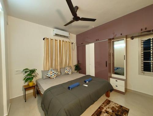 ein Schlafzimmer mit einem Bett und einem Deckenventilator in der Unterkunft Namasvi 2Bedroom AC House in Narasimharaja Puram