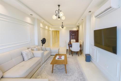 a living room with a white couch and a table at ALEX HOMES - Gleem Luxury Apartments with Direct Sea View in Alexandria