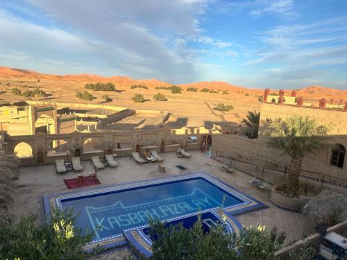 a swimming pool in the middle of a desert at Kasbah Azalay Merzouga takojt in Merzouga