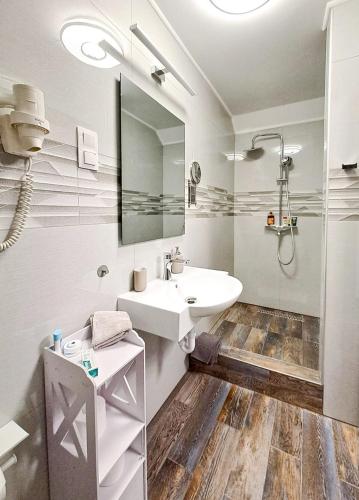 a white bathroom with a sink and a mirror at Zsúrterasz Vendégház in Etyek
