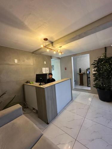 a man sitting at a counter in an office at Por do Sol Praia Hotel in Fortaleza