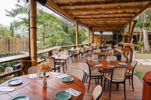 a restaurant with tables and chairs on a deck at Gaia Hotelaria in Teresópolis