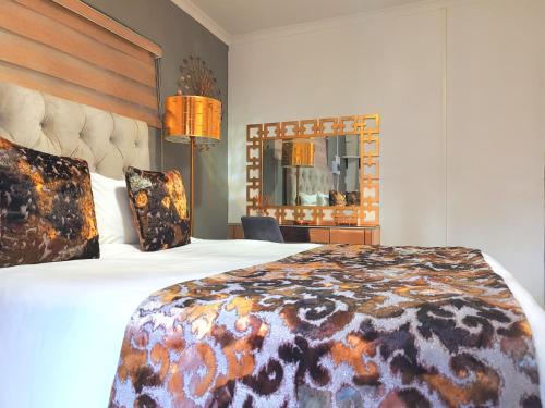プレトリアにあるHomes of Ace Goldの大きなベッドと鏡のあるホテルの部屋