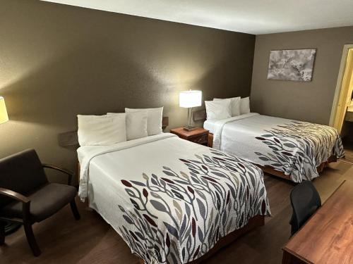une chambre d'hôtel avec deux lits et une chaise dans l'établissement Red Roof Inn & Suites Marysville, à Marysville