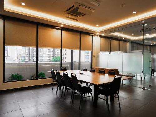 a conference room with a wooden table and chairs at Eco Roomy Hotel in Kuala Lumpur