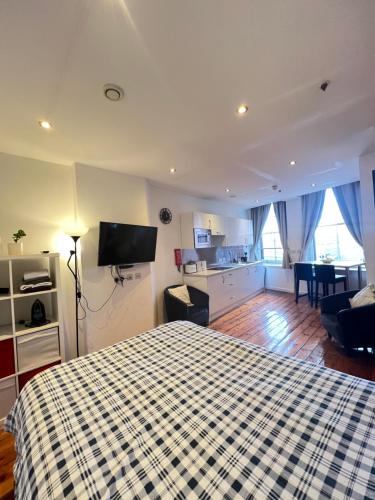 a bedroom with a bed and a living room at Quiet & Modern Studio in the Heart of Nottingham City Centre in Nottingham