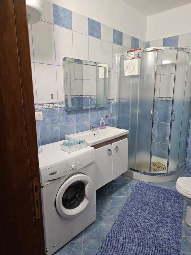 a bathroom with a washing machine and a sink at Roxy's house in Vlorë