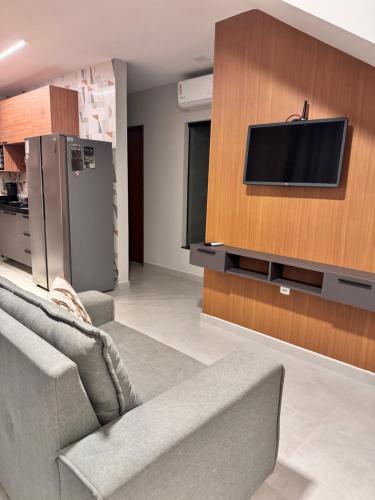 un salon avec un canapé et une télévision à écran plat dans l'établissement Pôr do sol house, à Aracaju
