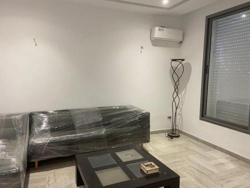 a living room with a couch and a table at Charmant appartement à Carthage in Douar ech Chott