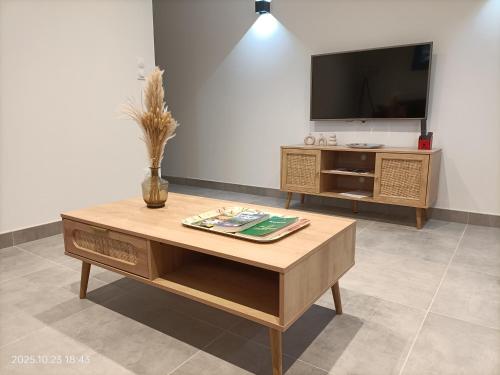 a living room with a coffee table and a flat screen tv at L'échappée Provençale in Les Granges-Gontardes