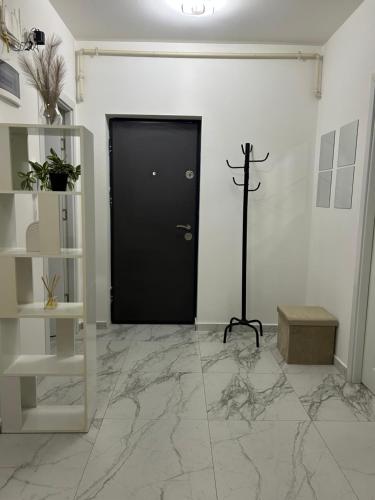 a black door in a white room with marble floors at Bella Home2 in Roşu