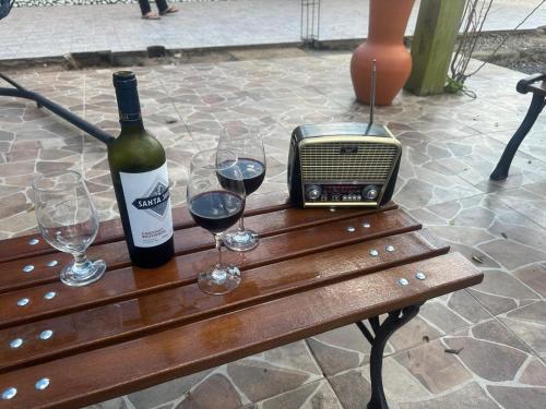 a bottle of wine and glasses on a wooden table at Sitio Encantos do Vale in Major