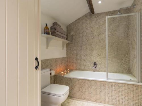 a bathroom with a bath tub and a toilet at 1 Bed in Ullswater 94066 in Watermillock