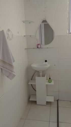 a white bathroom with a sink and a mirror at COP 30 - apartamento 2 quartos, sala e cozinha in Marituba