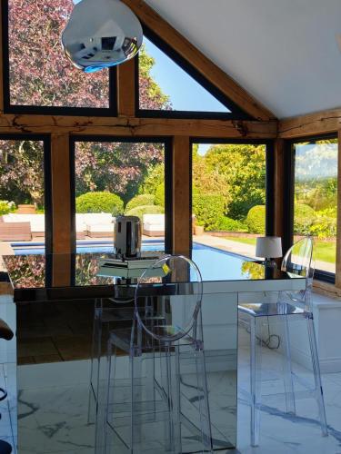 a kitchen with two chairs and a counter with windows at Harcombe Barn near Bristol in Bristol