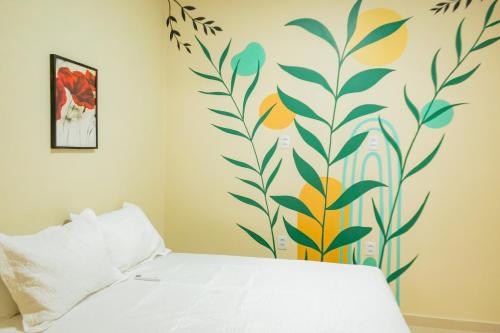 a bedroom with a bed with a floral mural on the wall at Eco Hotel Mãe De Sagui in Castanhal