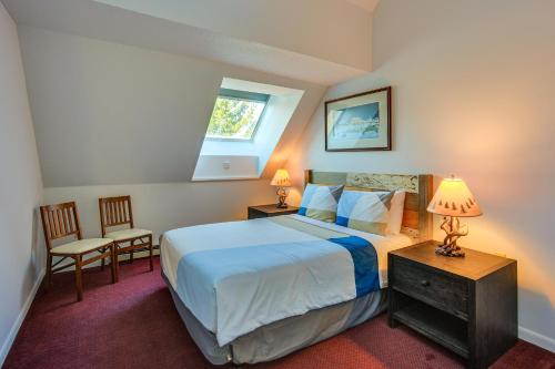 une chambre avec un lit et deux chaises et une fenêtre dans l'établissement Steps to Ski Lifts! Mountain Green Resort Retreat, à Killington Village