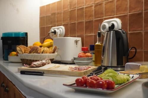 een aanrecht met tomaten en brood op een snijplank bij Ses Terrisses Hotel in Palafrugell