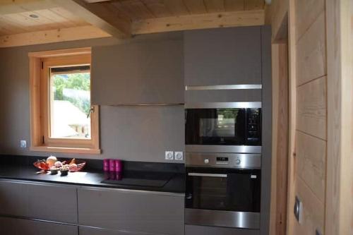 a kitchen with stainless steel appliances and a window at Cozy Chalet With Scenic View In Monêtier Les Bains in Le Monêtier-les-Bains