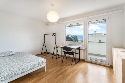 a bedroom with a bed and a desk and a window at EXQUIS Design 3-Room Apartment KNOLL I Zurich Lake View I Balcony I Family-Friendly in Männedorf