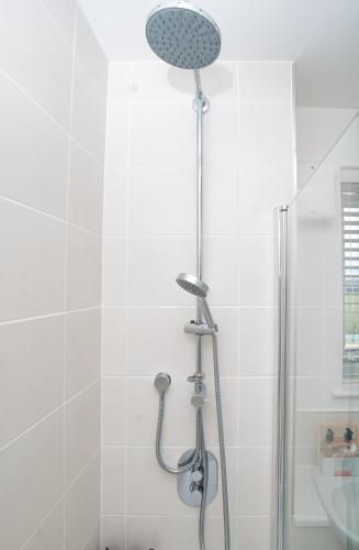 a shower with a shower head in a bathroom at Milton Keynes new 5-Bedrooms 14guests Contractor family holiday Free Parking in Milton Keynes