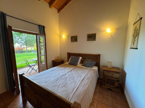 a bedroom with a bed and a sliding glass door at Casa de Campo Vale do Asno in Altura