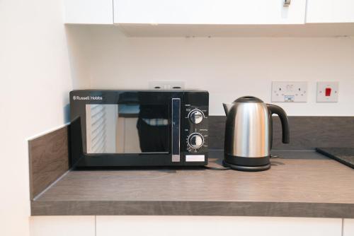 a microwave sitting on a counter in a kitchen at Milton Keynes new 5-Bedrooms 14guests Contractor family holiday Free Parking in Milton Keynes