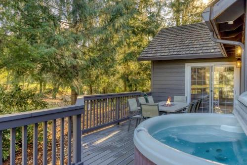 - un bain à remous sur une terrasse avec une table et des chaises dans l'établissement Lazy Bear Lodge · Spacious 6BR Lodge with Chef's Kitchen, Hot Tub, Golf Views and more, à Mount Hood Village
