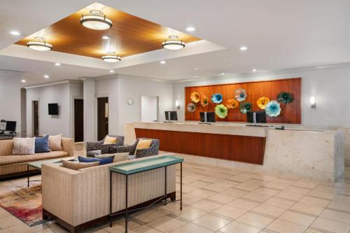 a lobby with a waiting room with couches and a bar at Eastgate Hotel - BW Signature Collection in Bellevue