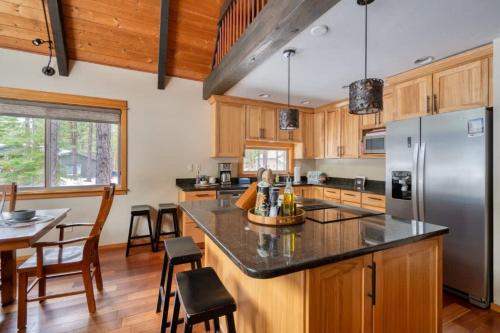 a kitchen with wooden cabinets and a stainless steel refrigerator at Spring Home 6 - Cozy 4BR Cabin in Black Butte Ranch w Fireplace in Black Butte Ranch